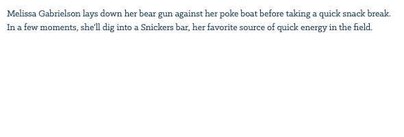 Melissa Gabrielson lays down her bear gun against her poke boat before taking a quick snack break. In a few moments, she’ll dig into a Snickers bar, her favorite source of quick energy in the field. 